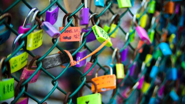 green chain link fence with assorted color padlocks